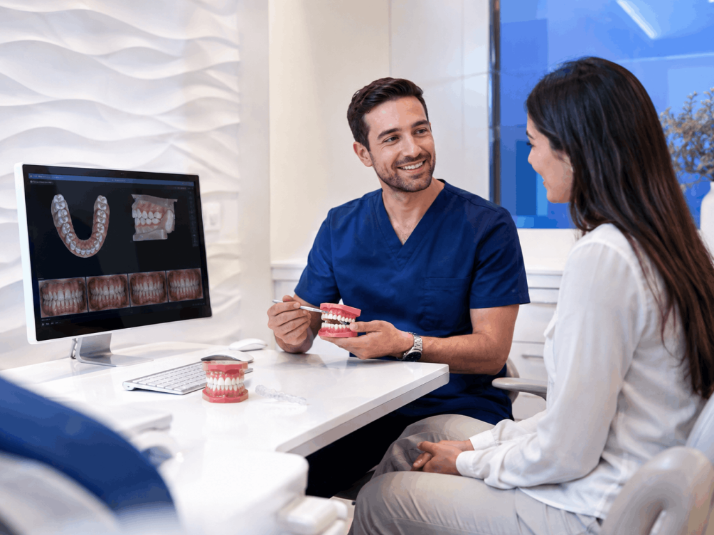 Dentista explicando opciones de ortodoncia a una paciente en una clínica dental de Sevilla